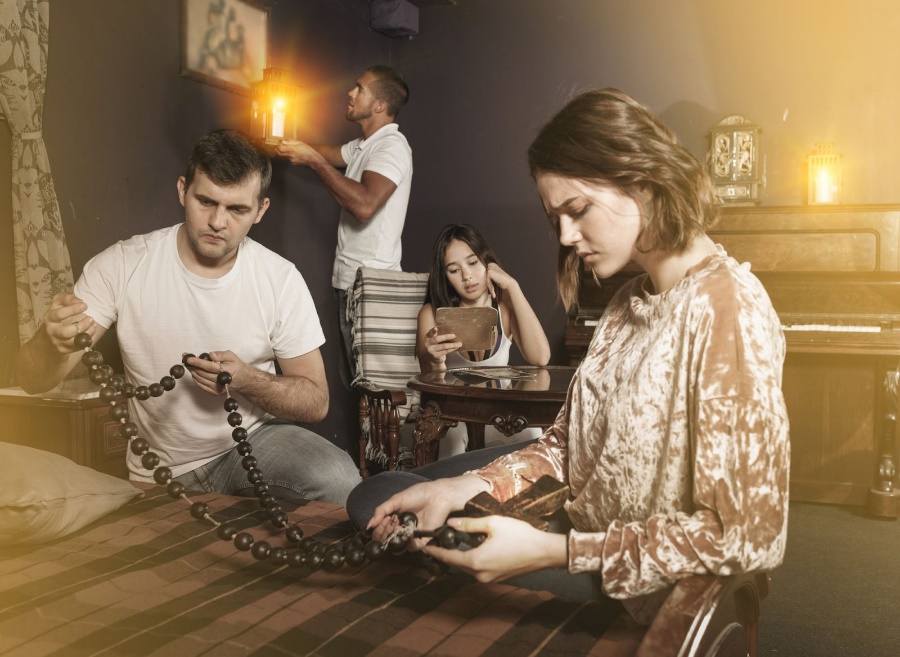 Four people working on puzzles in an escape room. 