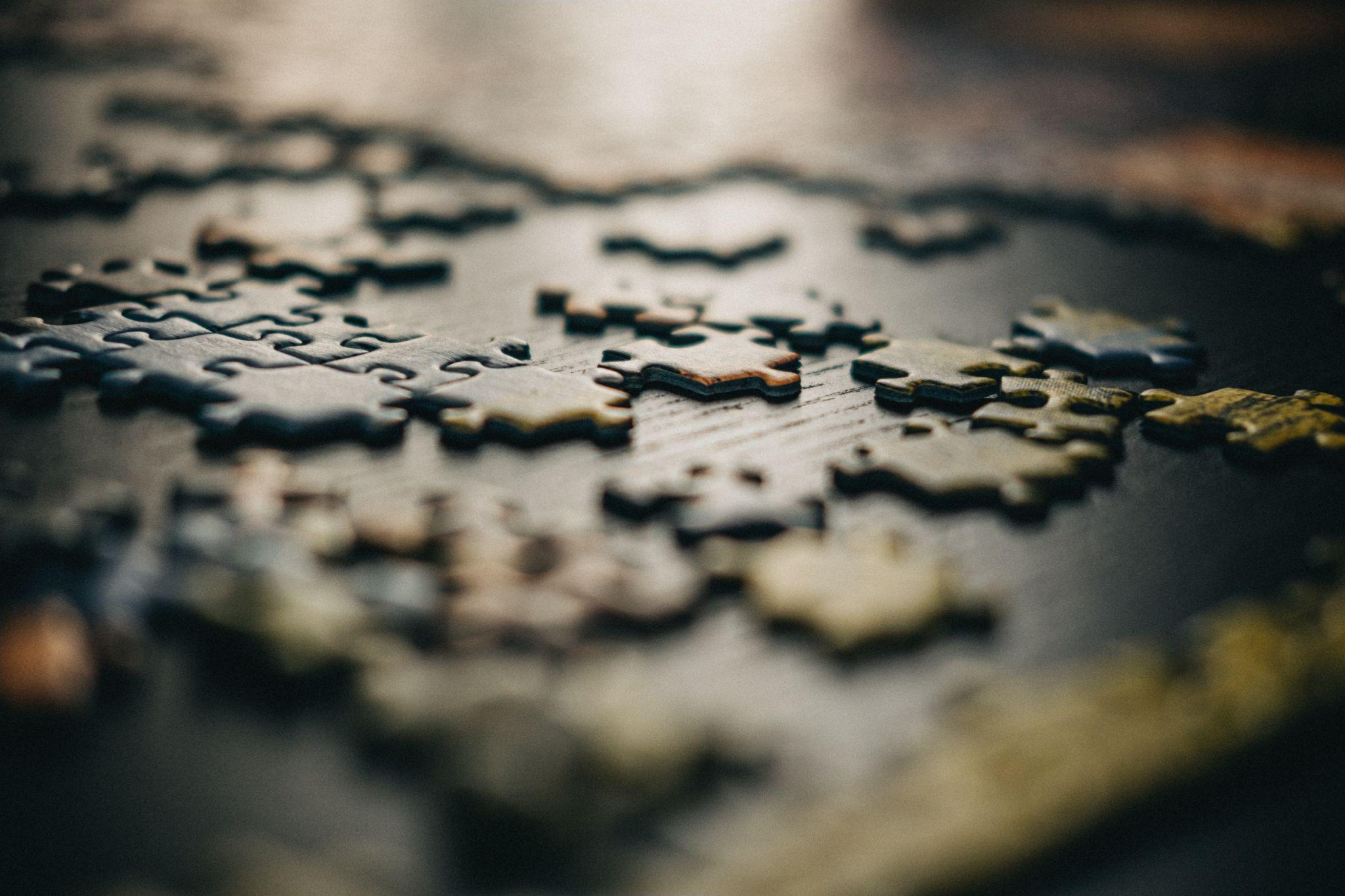 Jigsaw pieces laid out on a black wooden table