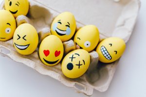 Photo of yellow painted eggs with various facial expressions