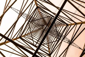 Photograph from inside an electric pylon showing its scaffolded structure- An image shot from below of an electricity pylon looking up through its inner structure