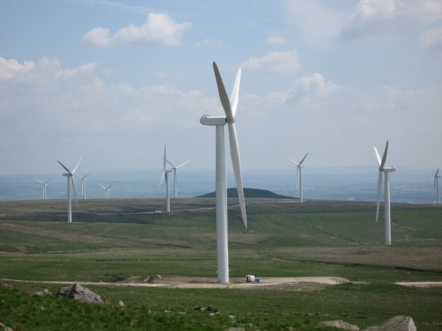 Photograph of three wind turbines set against grey clouds