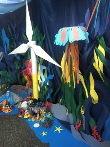 Photograph of a student-made seascape with a wind turbine and a large jellyfish amongst other animals and plants