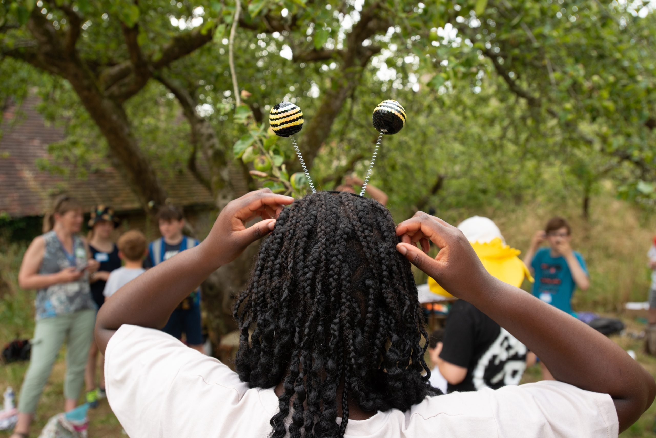 Photograph of the back of a student's head wearing 'pollinator' antennae