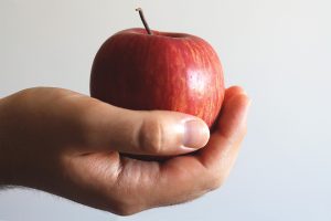 Photograph of a hand holding a red apple