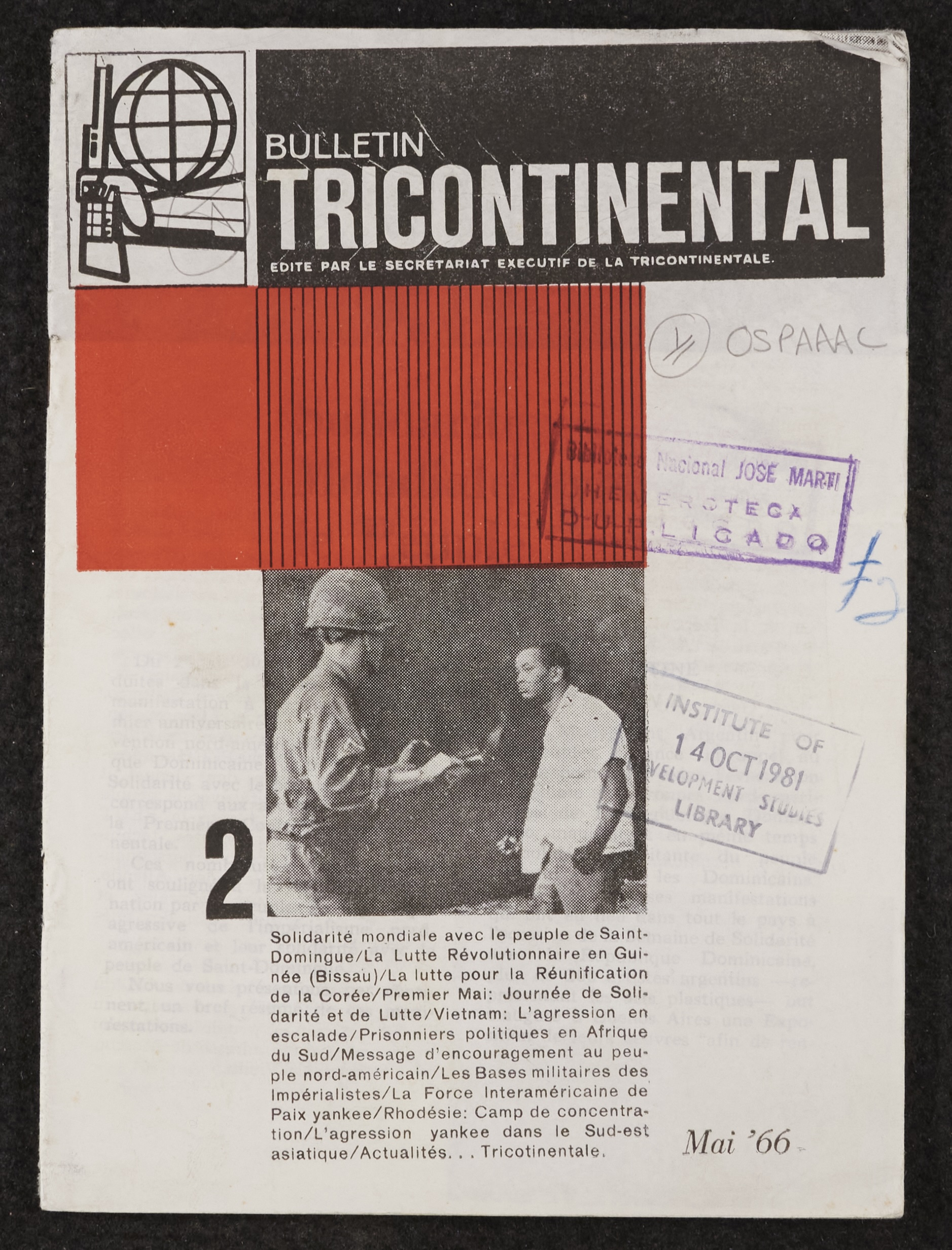 Image credit: Copyright OSPAAAL (1985). Tricontinental Review, front cover of No. 2. Accessed via British Library for Development Studies Legacy Collection. Scan copyright University of Sussex (2024). Used with kind permission. All rights reserved. The scanned image shows the cover of the Tricontinental Bulletin, Issue 2. The title is in white text on a black banner across the top of the page. Below that is a block of red colour and a black and white photo of a white soldier facing a black man in civilian clothes. Below the photo is the first paragraph of an article in French. Library stamps are visible on top of the image.