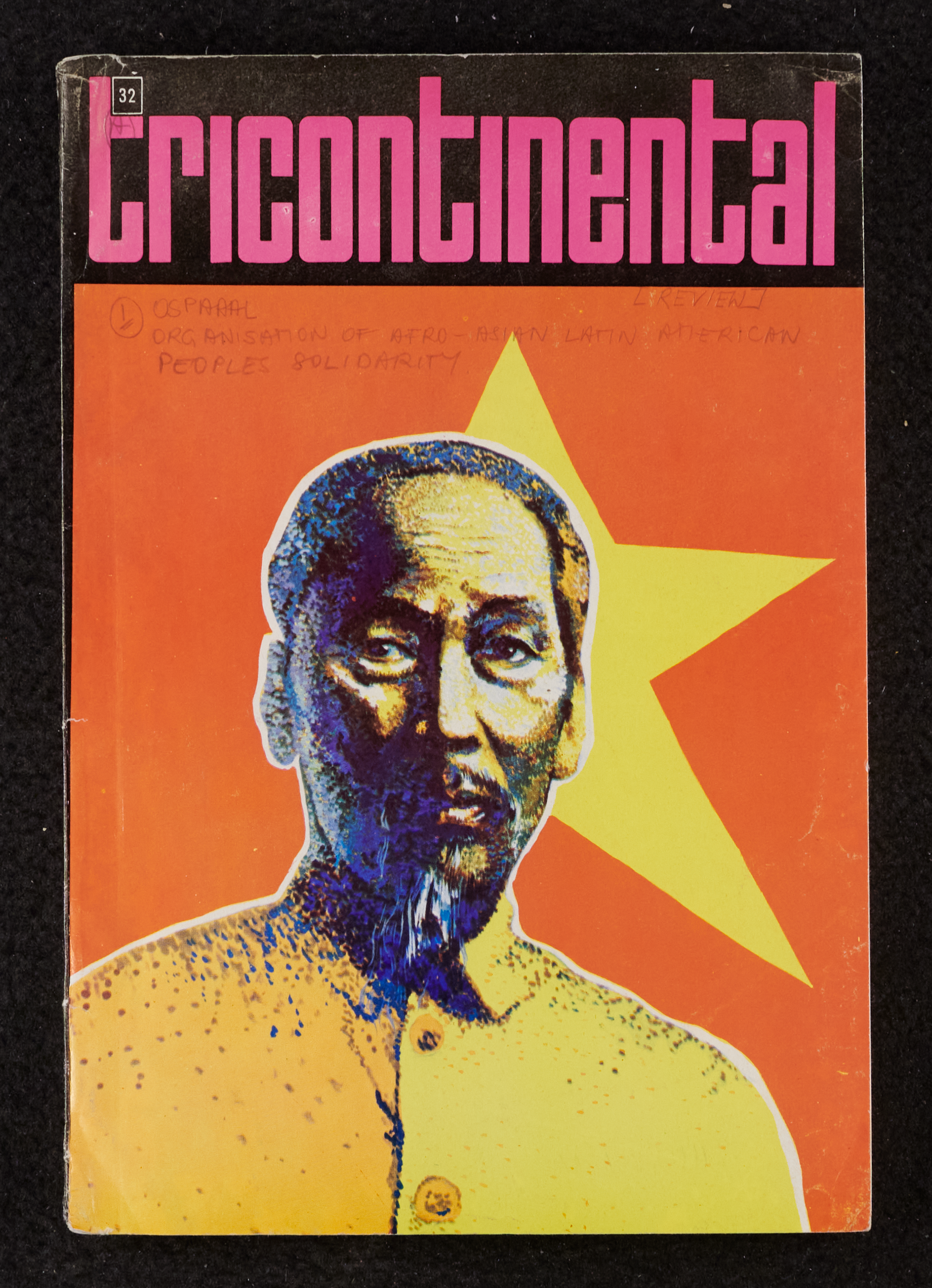 Image credit: Copyright OSPAAAL, Tricontinental Review, no. 32 (1972). Accessed via British Library of Development Studies Legacy Collection. Scan courtesy University of Sussex (2024). Used with kind permission. All rights reserved. The cover of issue 32 of Tricontinental. The title is in pink text on a black background. The image is of Ho Chi Minh facing the camera on an orange background. There is a yellow star shape behind his head.