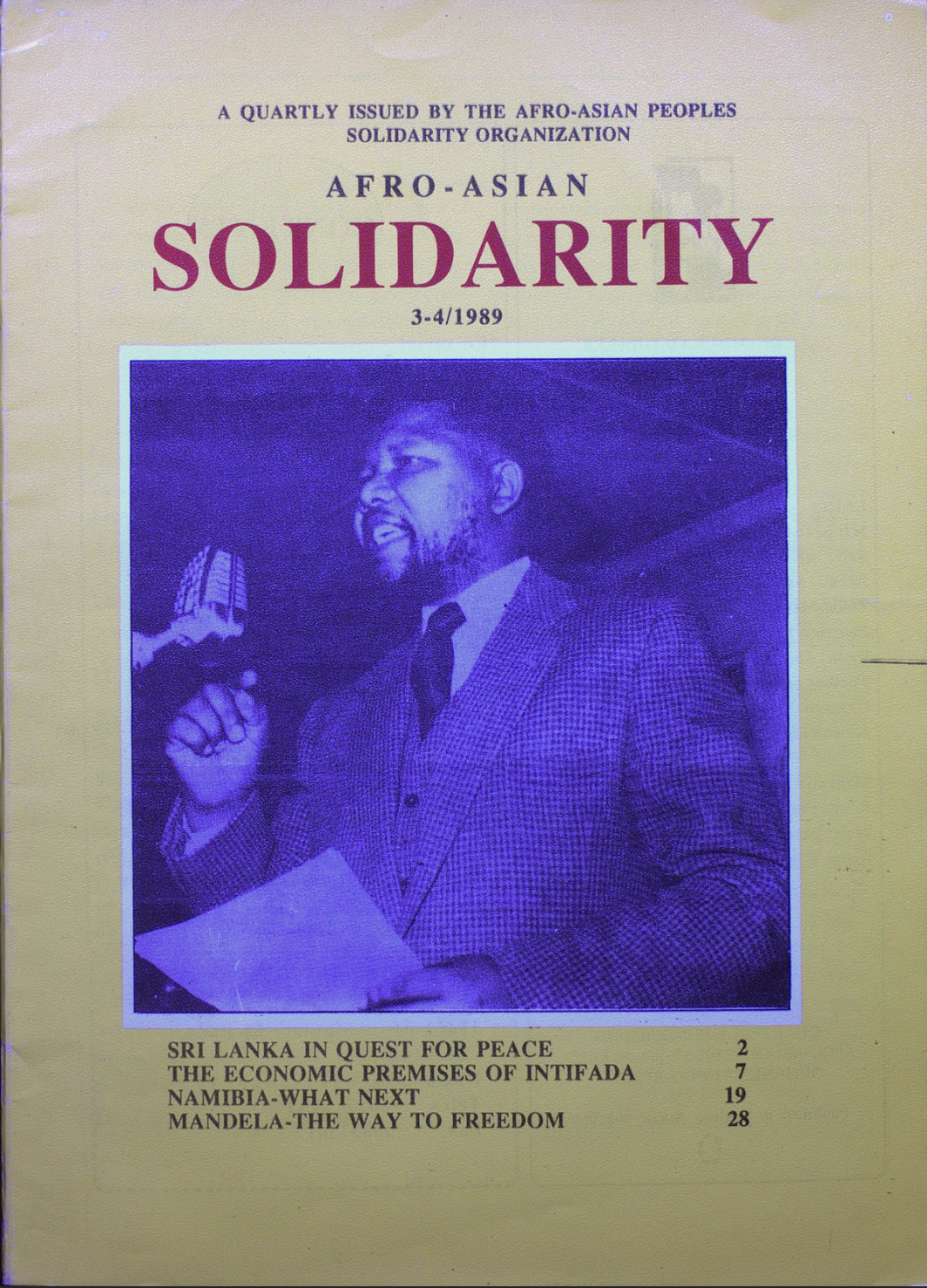 Image credit: Copyright AAPSO (1989). Front cover of Solidarity, no. 3-4 (1989). Available from the International Institute of Social History (Amsterdam). Scan by Lavanya Nott (2025). Used with kind permission. All rights reserved. Front cover of Solidarity, no. 3-4 (1989), depicting Nelson Rolihlahla Mandela in a three-piece tweed suit reading a written speech through a microphone.