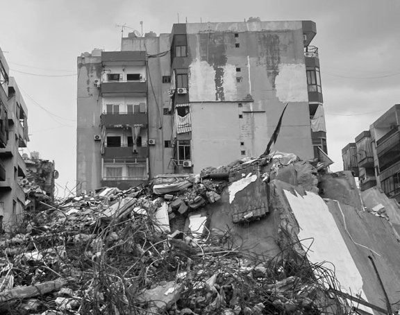 Image credit: Copyright (2025). Photograph by Iman Makdisi. Used with kind permission. All rights reserved. The author's black and white photograph of a family friend's bombed-out neighbourhood in heavily-targeted south Lebanon shows the remnants of a still-standing apartment block surrounded by rubble, strikingly similar to the 1978 photograph above.