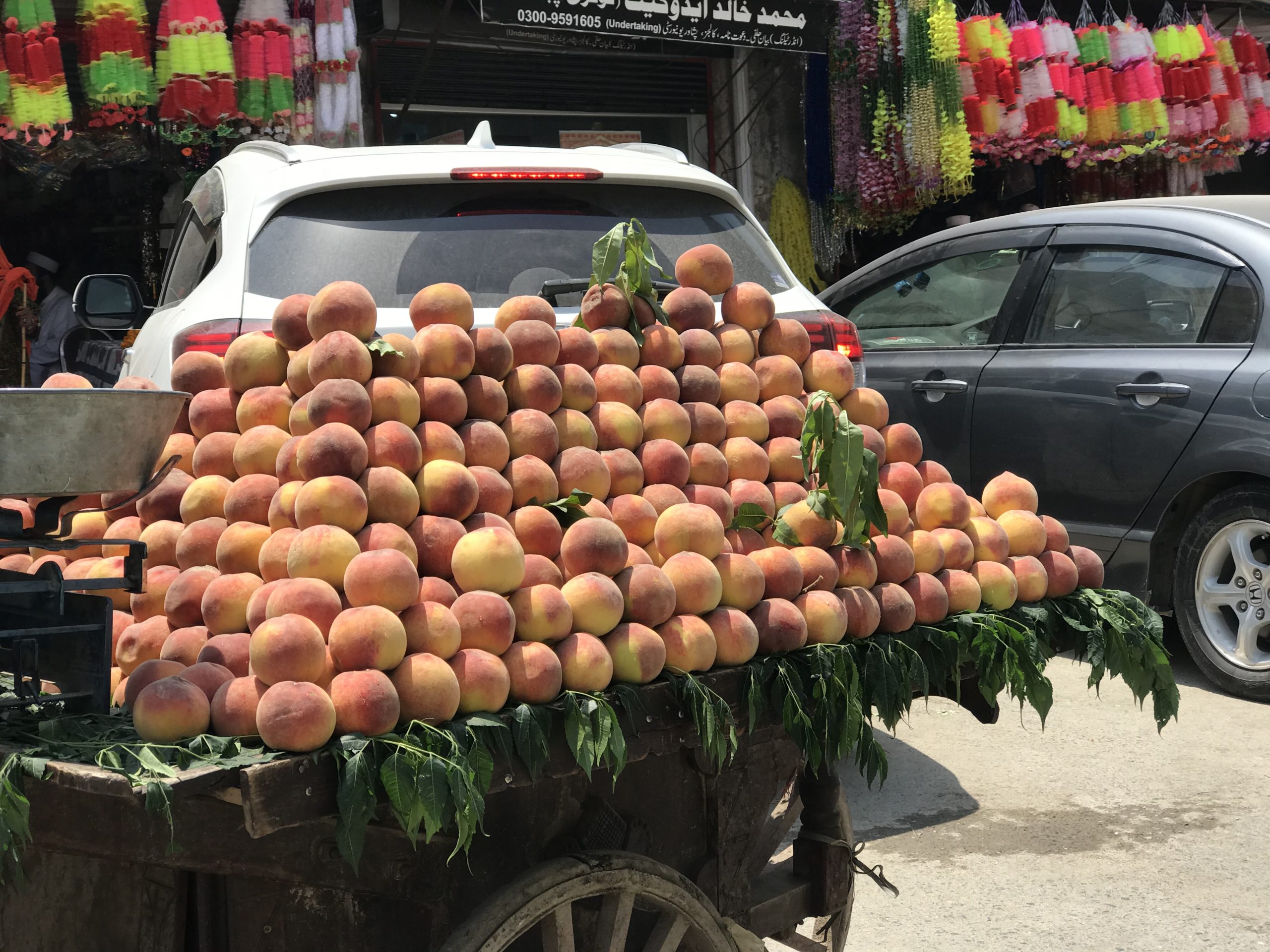 Photo of peaches piled up on a market stall.